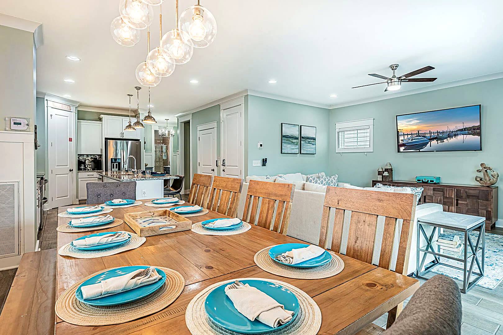 Farmhouse dining table set for ten at 122 Sandcastle Court, open to the living room