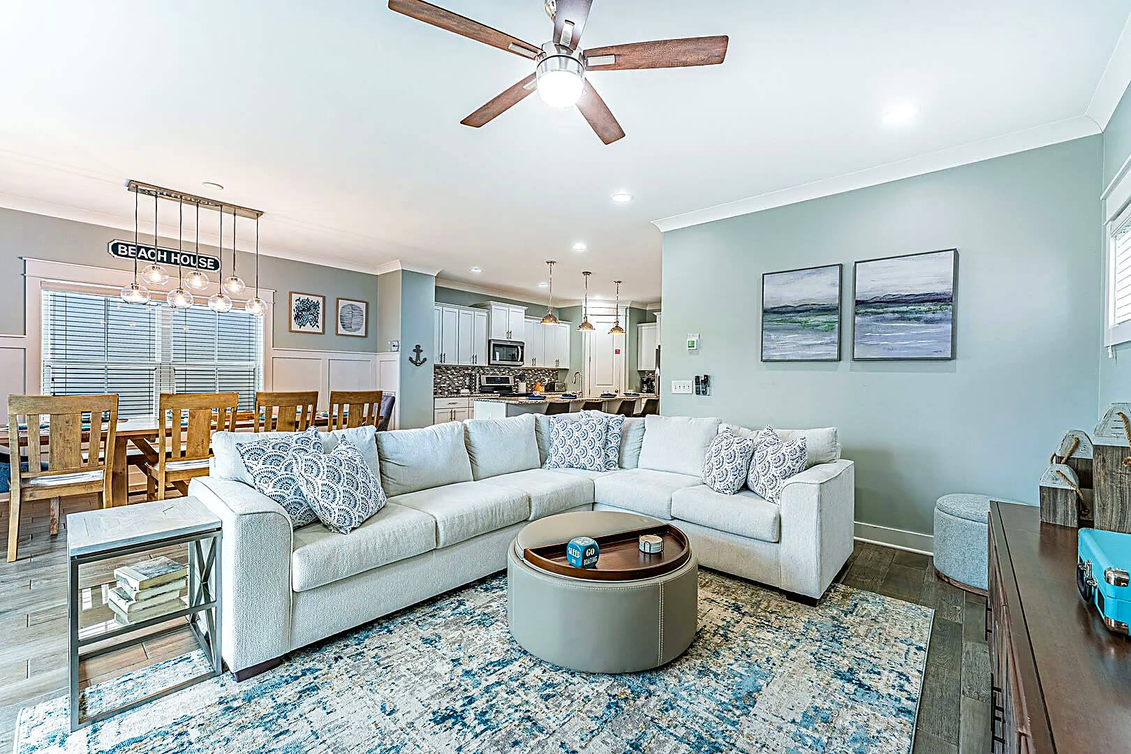 Open plan living, dining and kitchen space at 122 Sandcastle Court with a large sectional sofa and coastal furnishings
